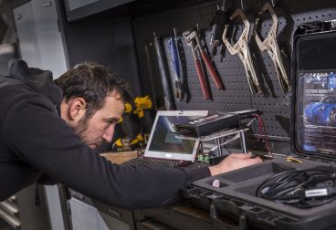 A mechanic working on part of a camper